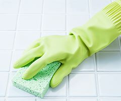 浴室の清掃をする手